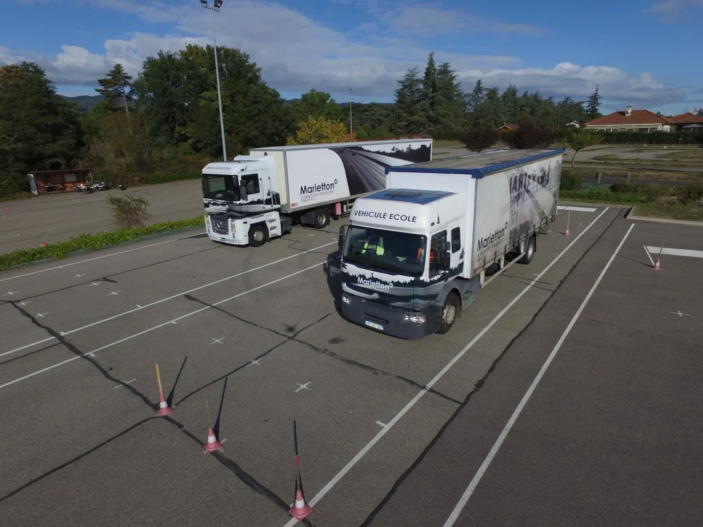 Deux poids lourds en manœuvre sur le plateau d’entraînement balisé de plots, chez Marietton Pro